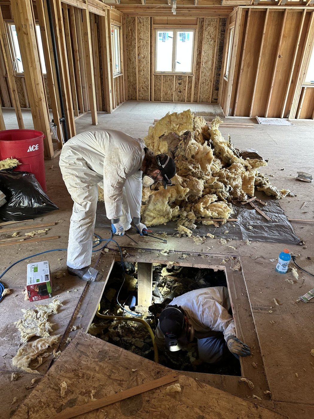 Crew pulling old insulation and subfloor during an interior demolition
