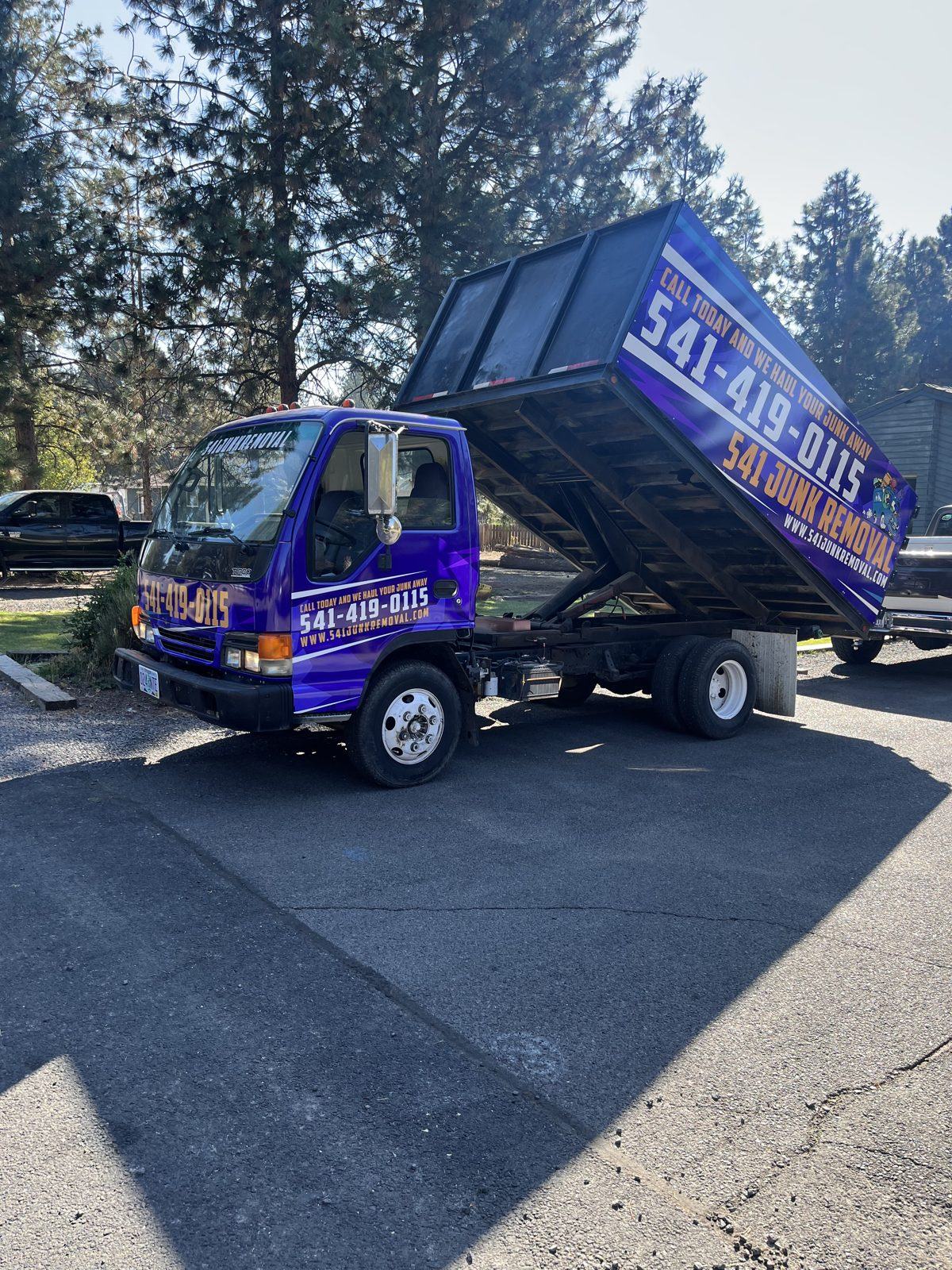 The 541 Junk Removal truck tipping a full load at the end of a job