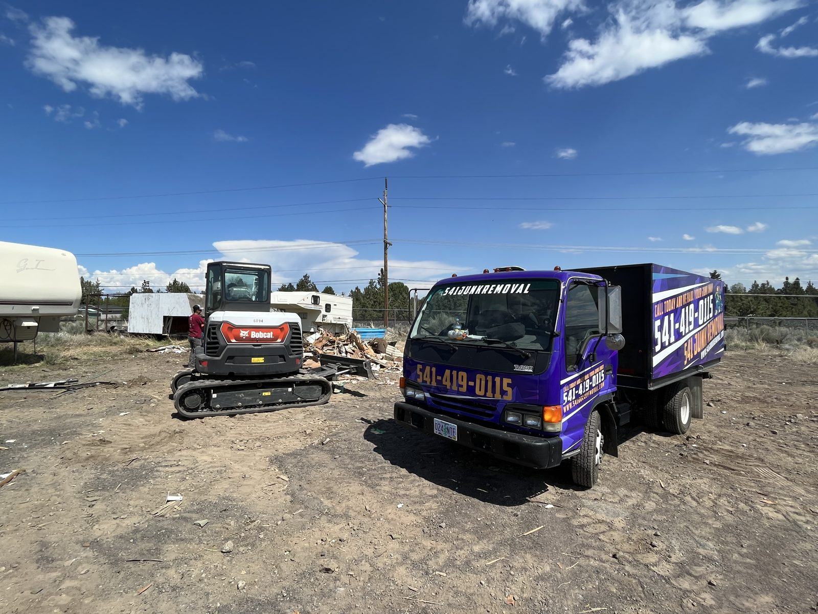 Truck and mini excavator on site for a demolition and clear-out in Central Oregon